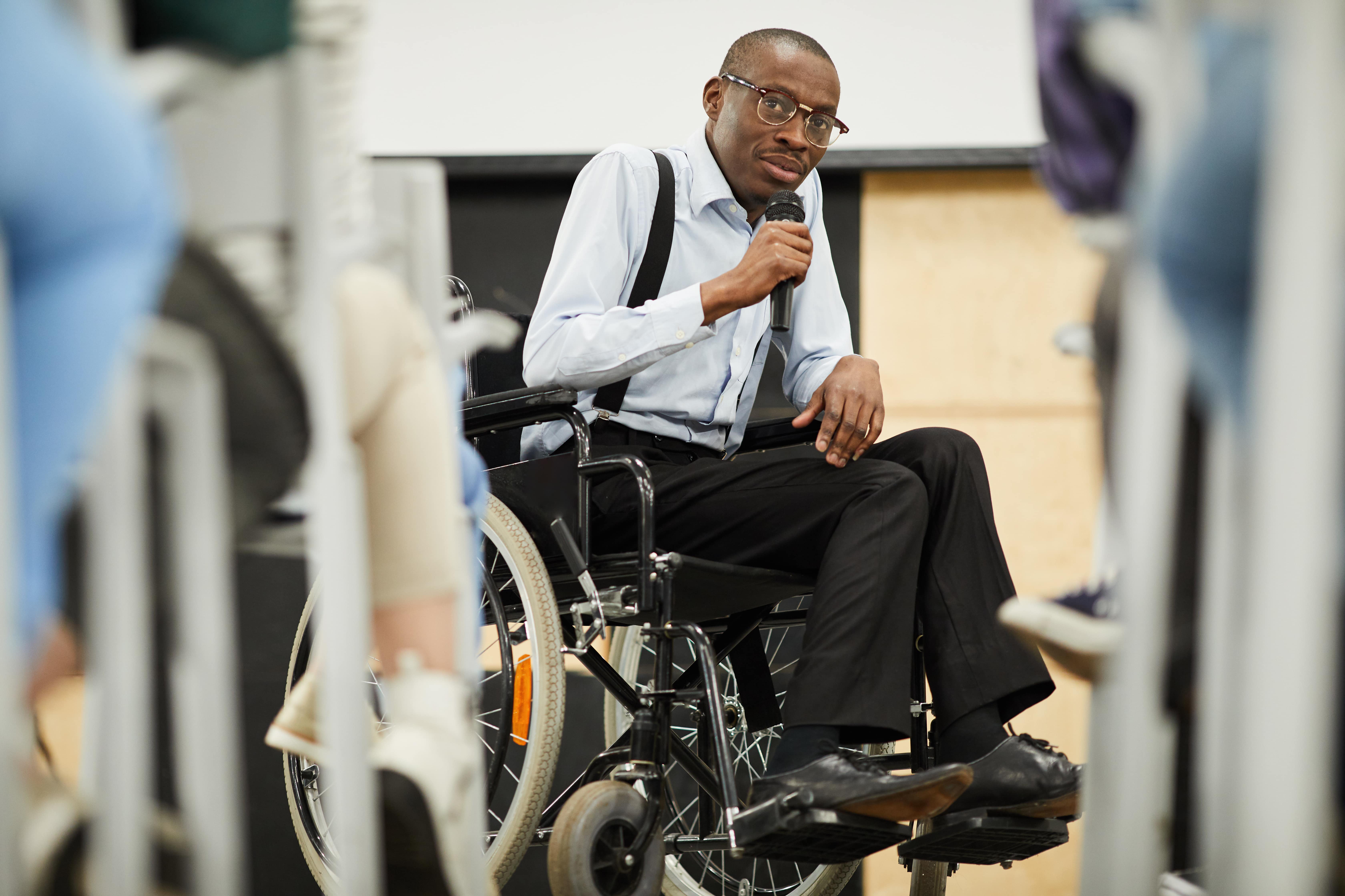 Image of a professional speaker in a wheelchair making a memorable speech with next level authenticity 